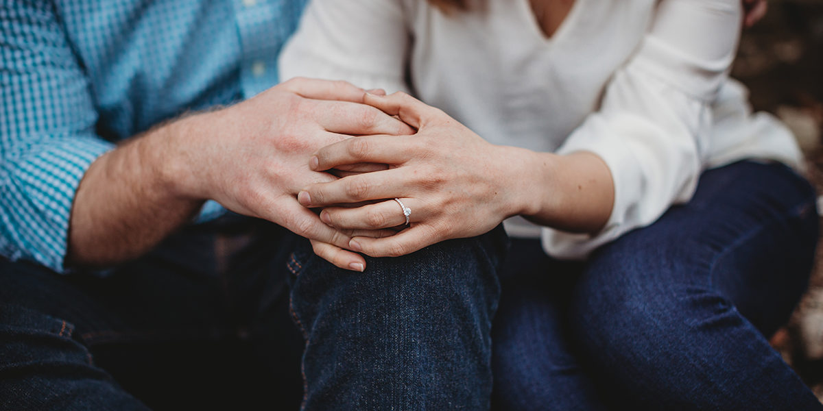 couple sitting holding hands showing sober support