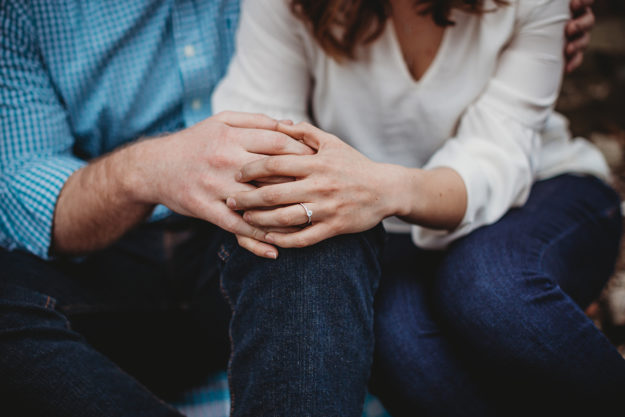 couple sitting holding hands showing sober support