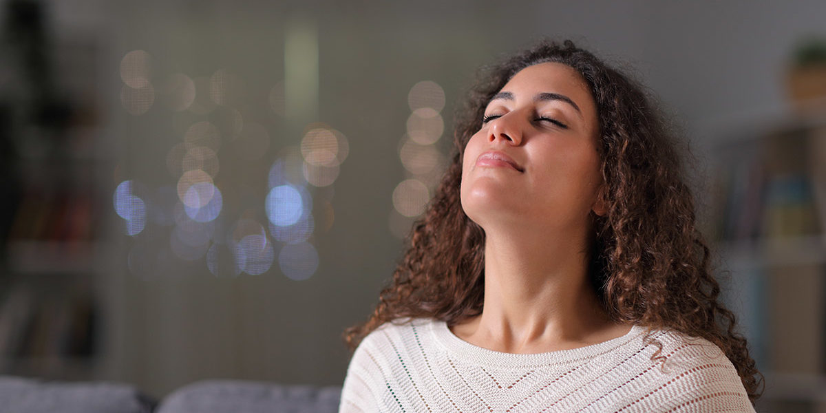 woman grinning practicing deep breathing