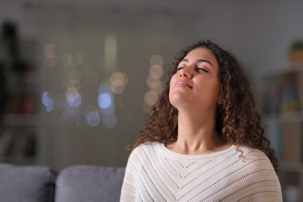 woman grinning practicing deep breathing
