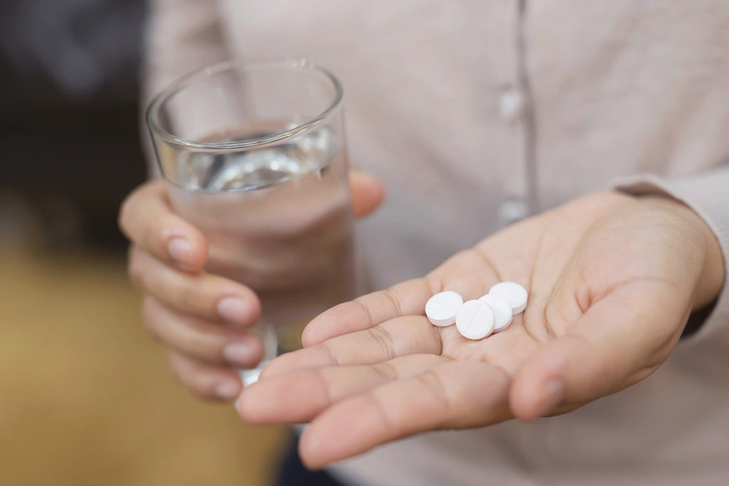 hand holding several pills showing drug use