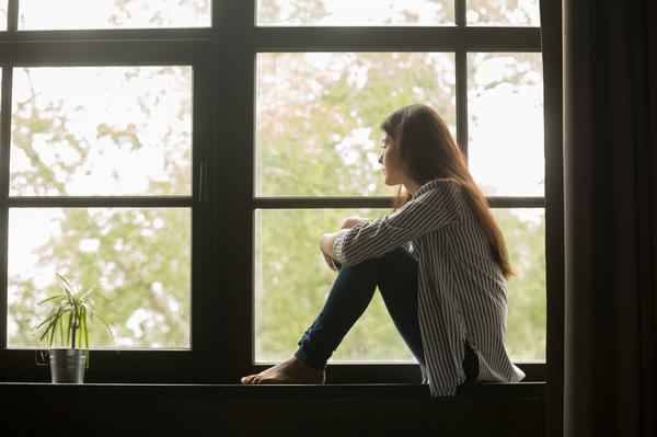 woman sitting in the windowsill pondering substance abuse treatment programs
