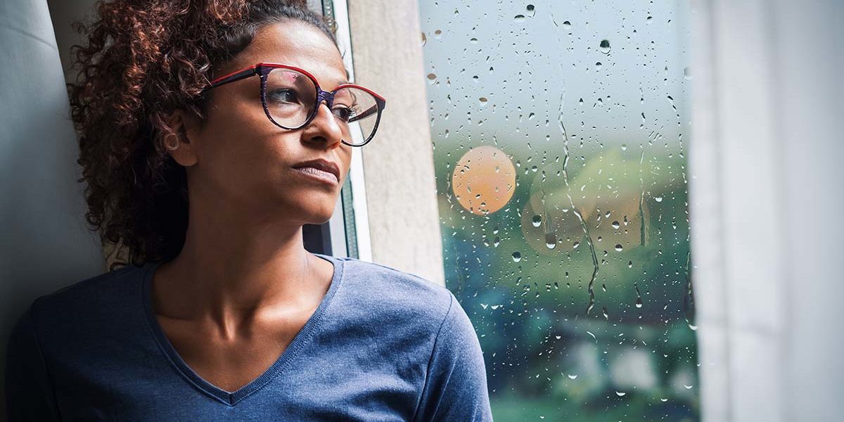 woman looking out window thinking why do i need alcohol abuse counseling