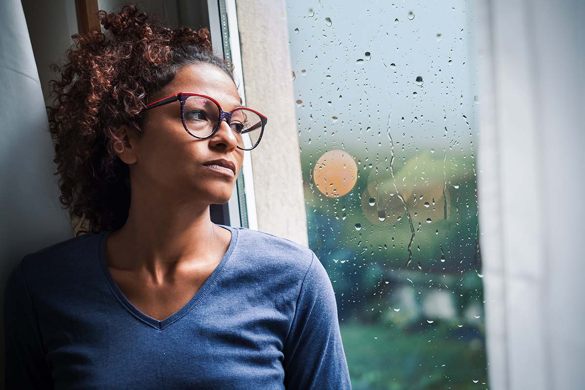 woman looking out window thinking why do i need alcohol abuse counseling