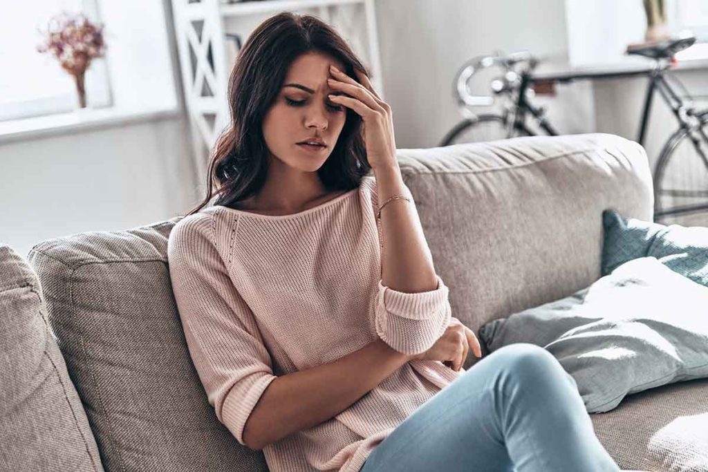 a woman suffers from the symptoms of prescription drug addiction and wonders about the signs of prescription drug abuse