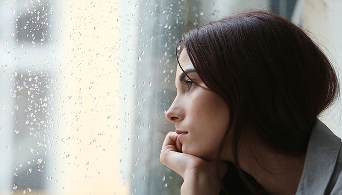 woman with comorbid anxiety reflecting by the window