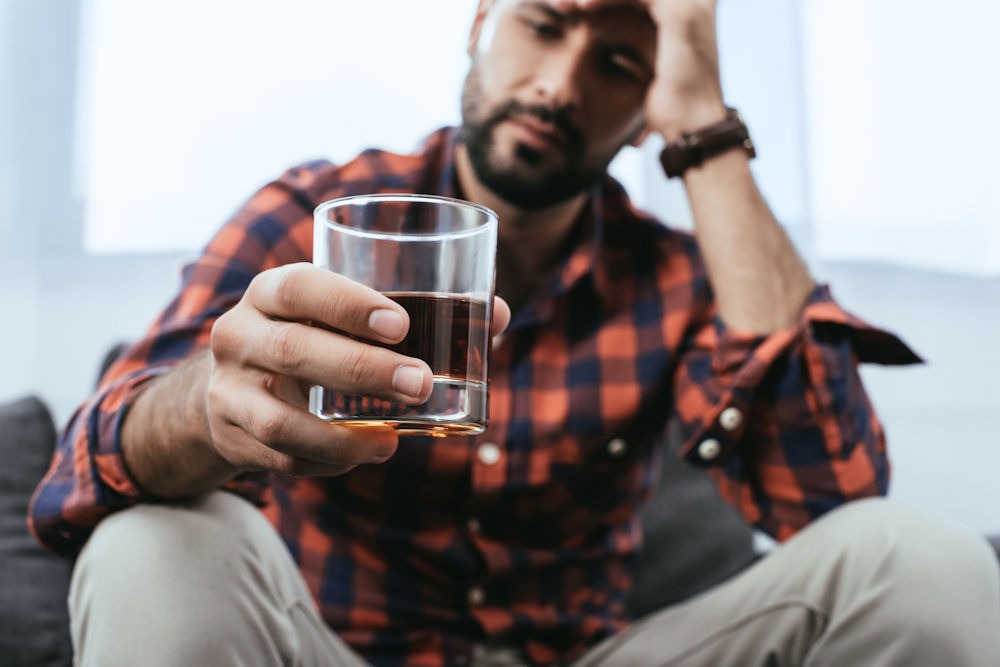 man holding a glass of whiskey