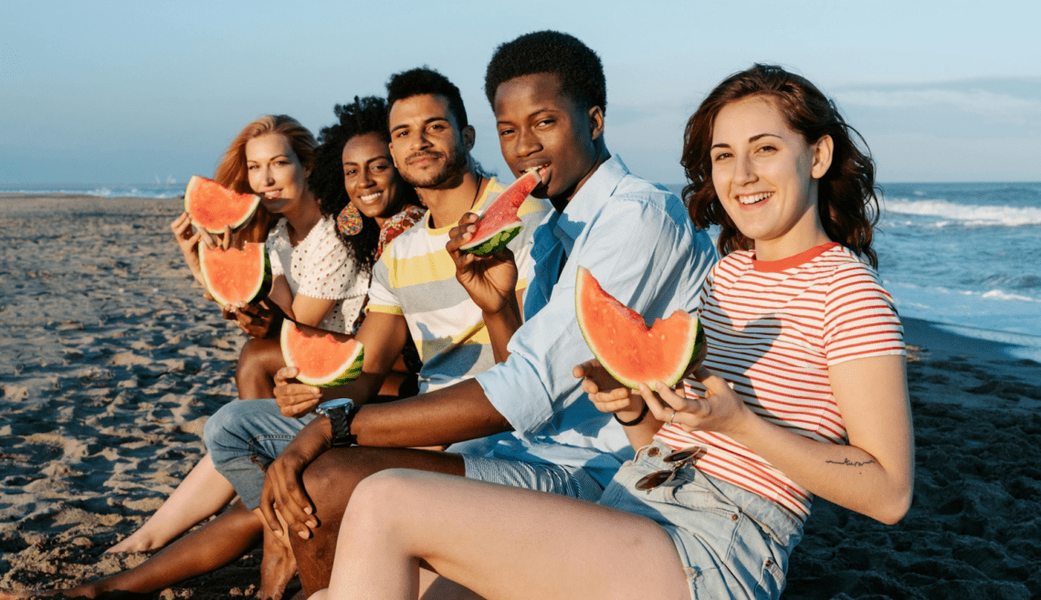 woman smiling with her arms up while enjoying a sober summer