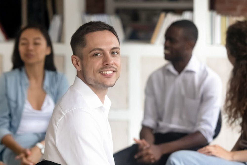 man-smiling-while-in-group-therapy-for-alcoholism