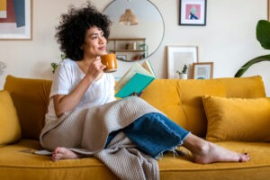 woman-drinking-tea-and-reading-a-book-on-the-couch