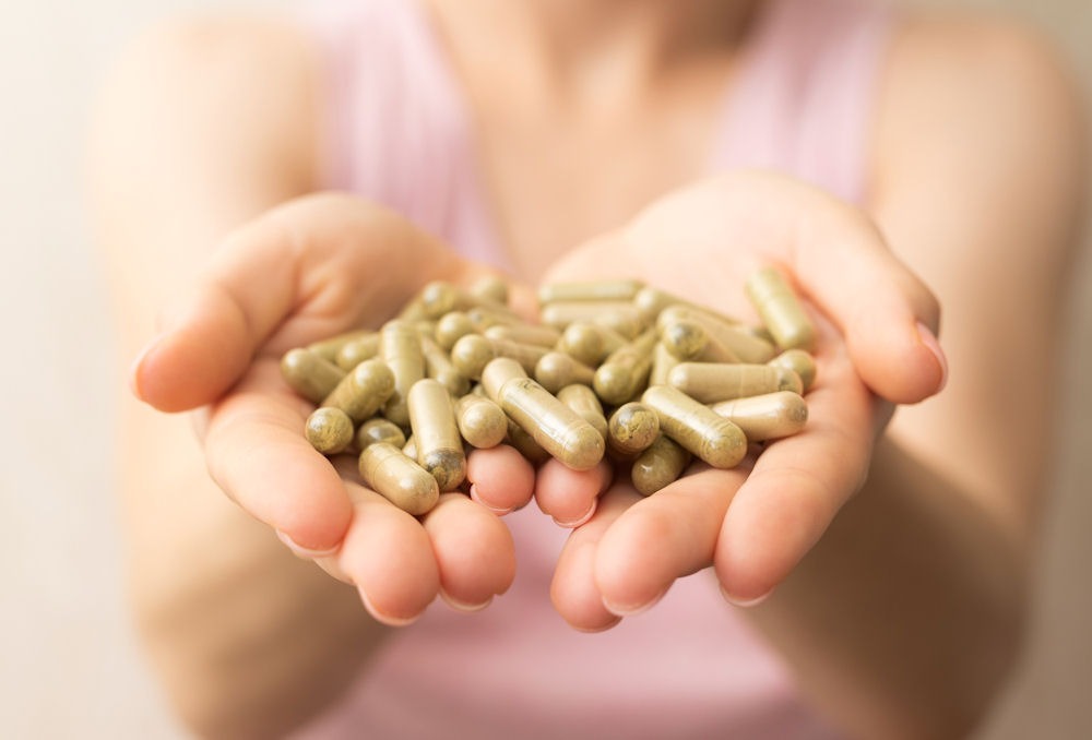 a-woman-holding-a-handful-of-kratom-pills