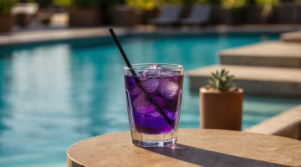 purple drink glass on side table by the pool on beach summer res