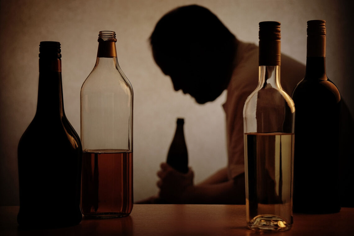 man-drinking-surrounded-by-alcohol