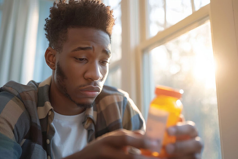 a man staring at a pill bottle