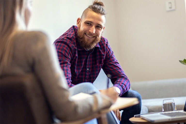 man smiling in therapy for alcohol addiction