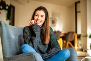 a-woman-smiling-at-home-sitting-on-the-chair