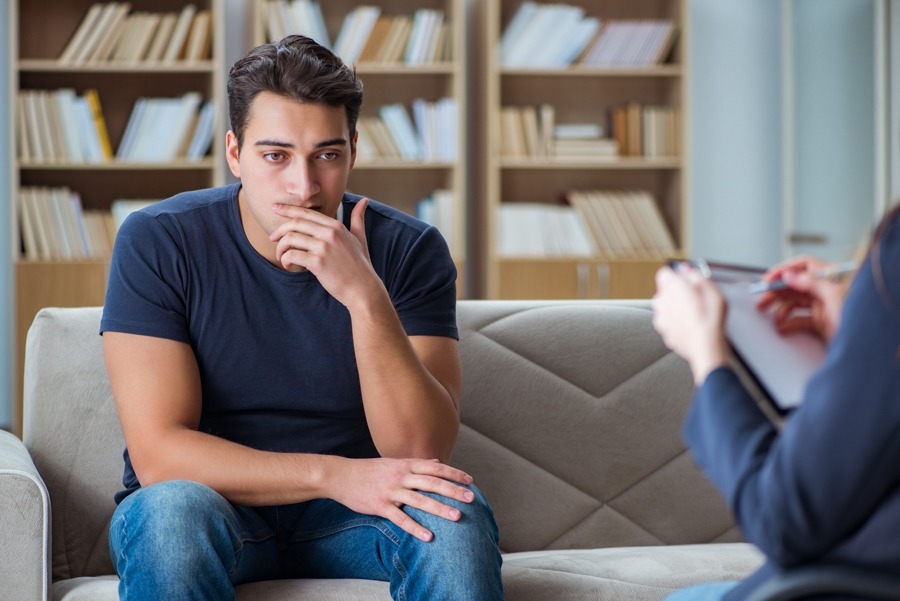 A man sitting on a couch seeking help for his manic episodes
