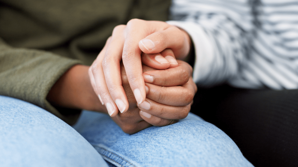 a pair of hands comforting someone in recovery