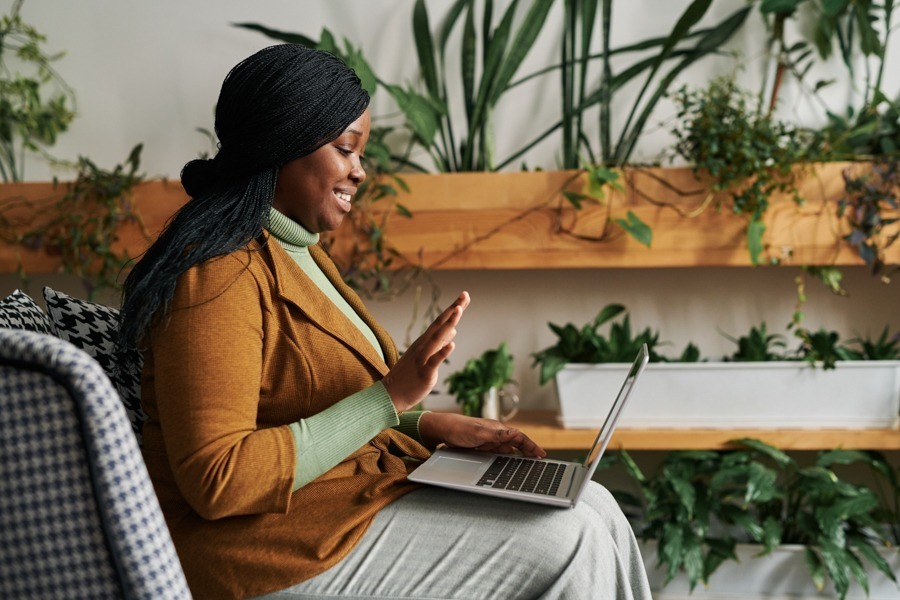 a woman waving on a telehealth call