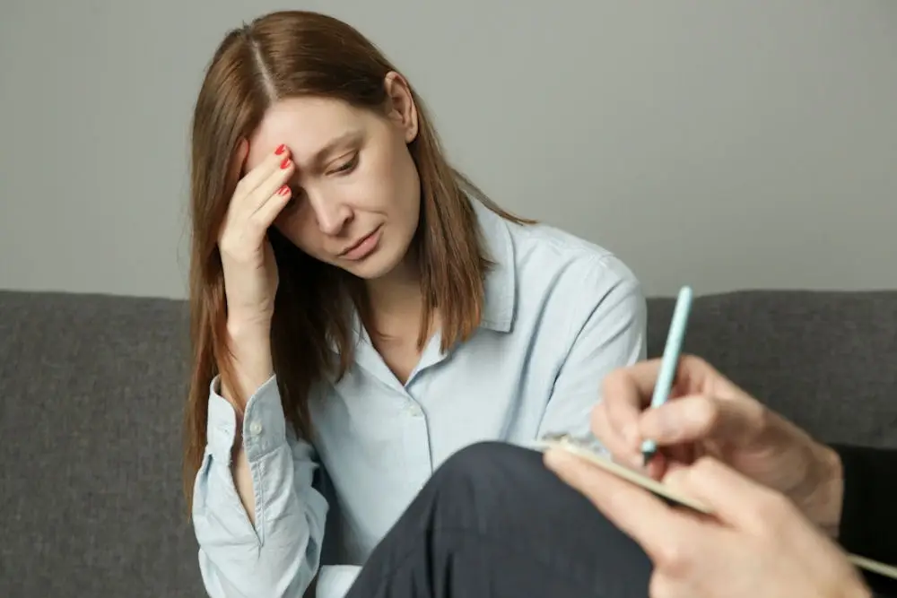 a woman with hand on head in distress in therapy