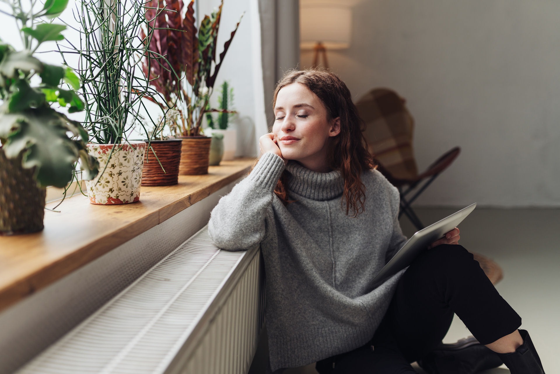 a woman smiling by the windowsill