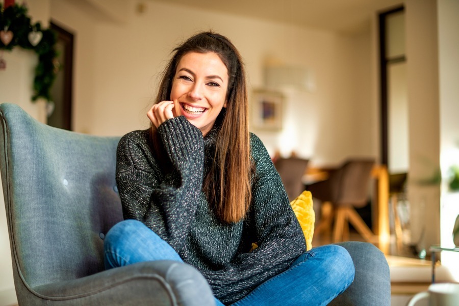 a woman smiling at home sitting on the chair