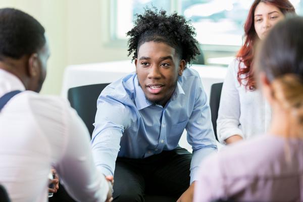 man shaking hands with group during substance abuse treatment programs