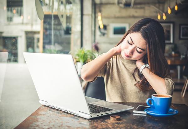 woman with chronic neck pain looking up substance abuse treatment programs at cyber cafe