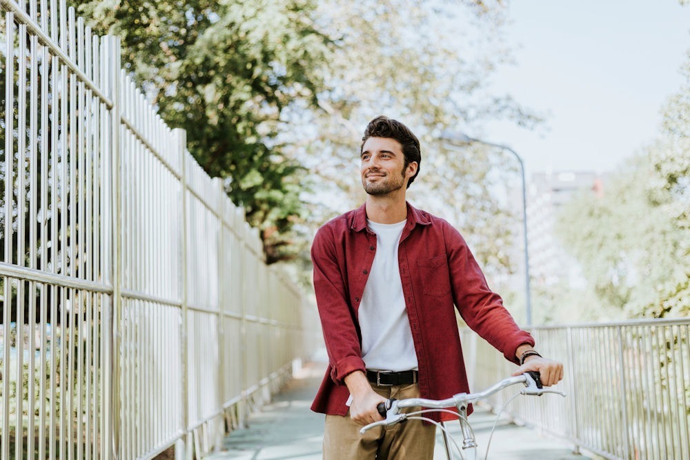 man in recovery walking outside wth a bike