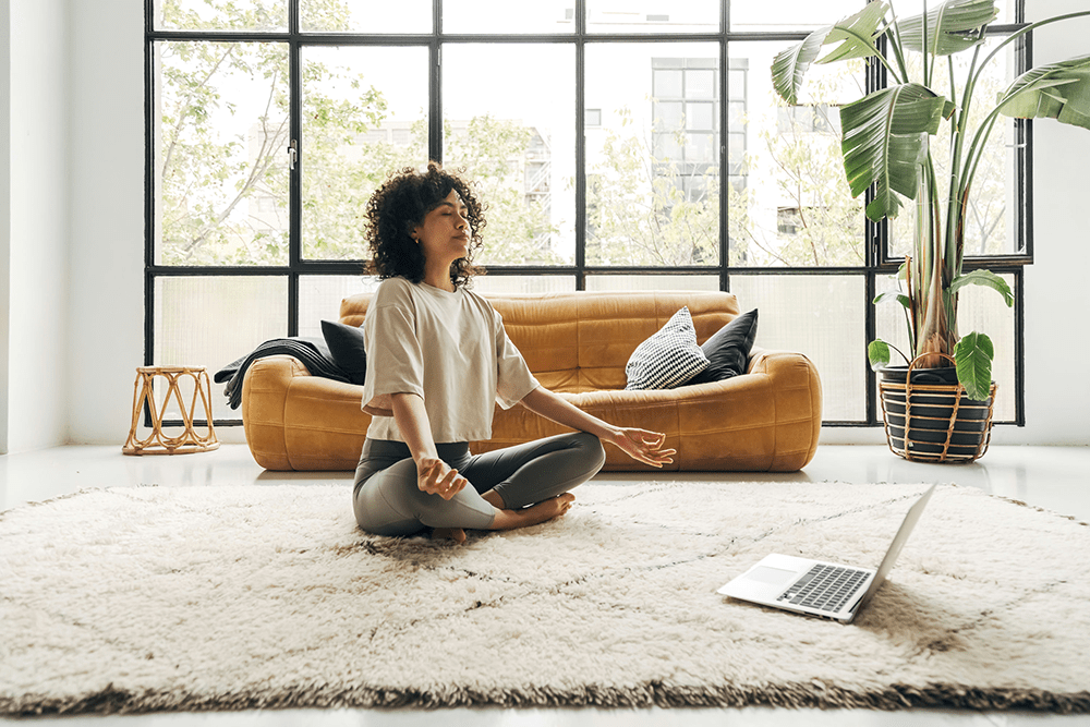 woman practicing yoga at home as part of holistic therapy