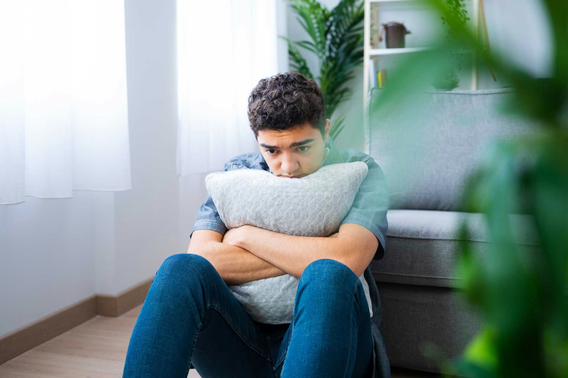 man sitting on the floor holding a pillow in fight-or-flight mode