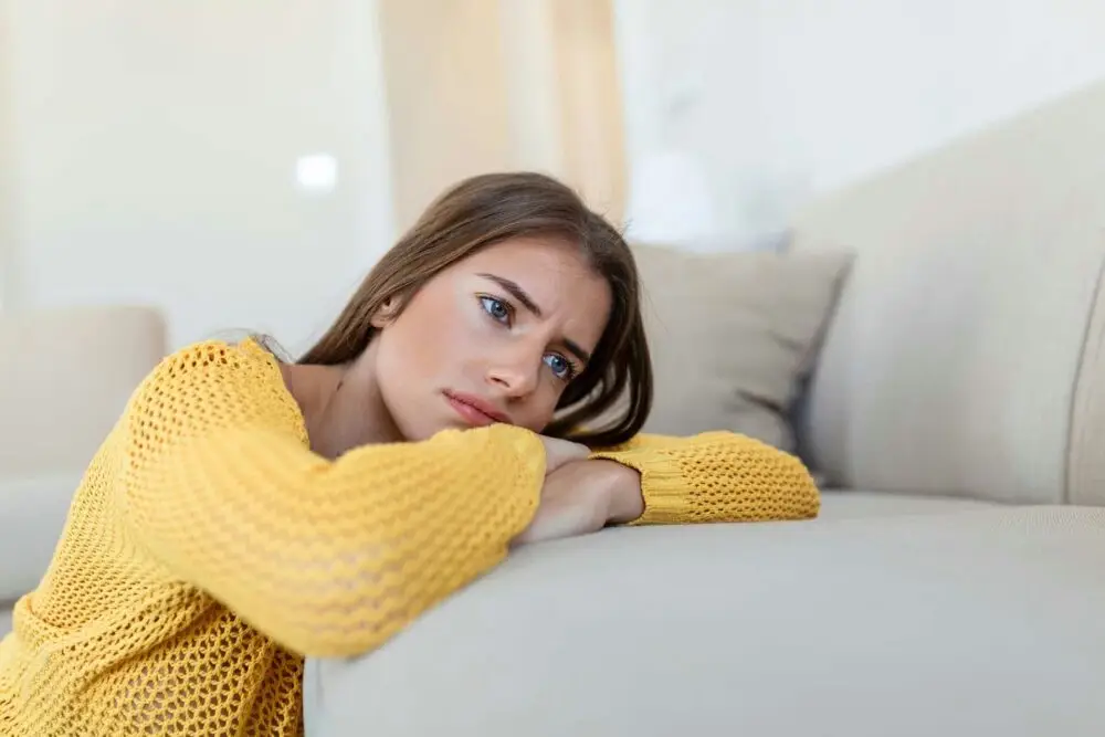 a-woman-laying-on-couch-staring-off